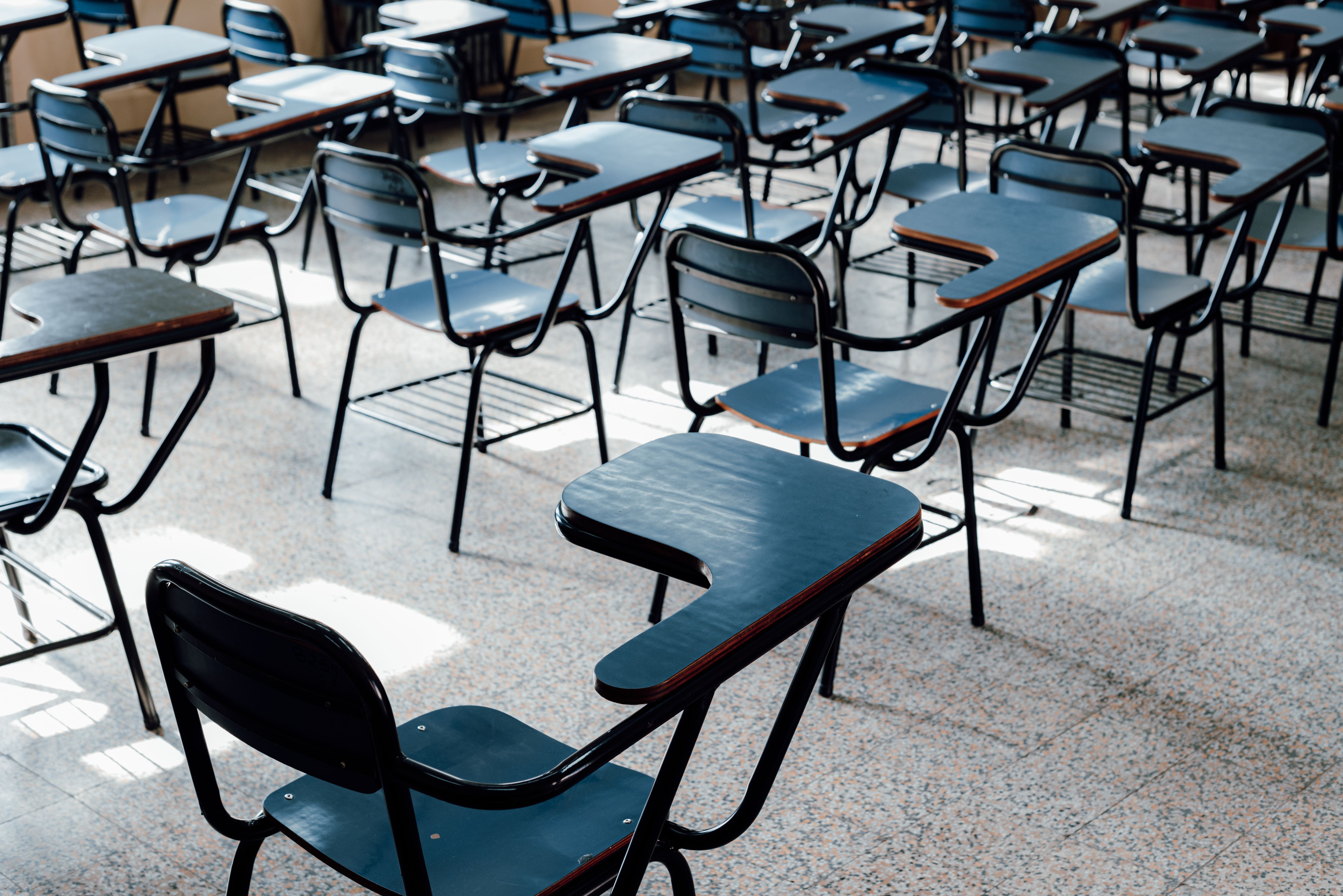 Rows of empty desks in a classroom